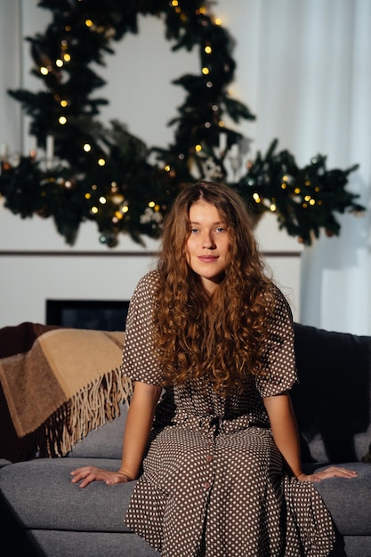 Muito jovem ruiva relaxando em casa em um sofá olhando para a câmera