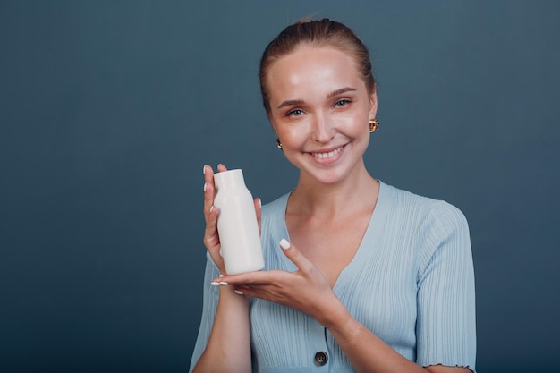 Muito jovem segura garrafa com espaço vazio Shampoo e condicionador