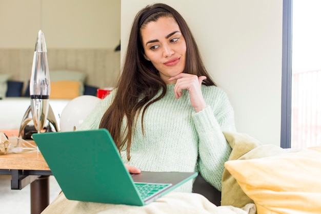 Muito jovem trabalhando em casa com um design de interiores de casa de laptop