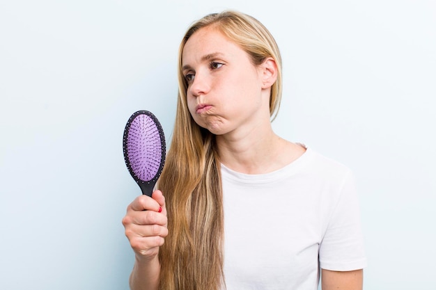 Muito loira jovem adulta com um pente de cabelo