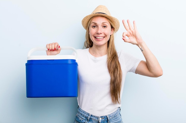 Muito loira jovem adulta com um piquenique de verão de geladeira portátil