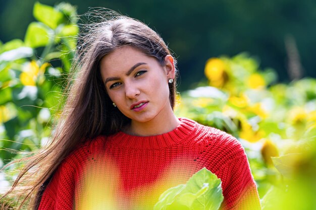 Muito sensual jovem morena em um campo de girassóis em um suéter vermelho mulher feliz ao ar livre