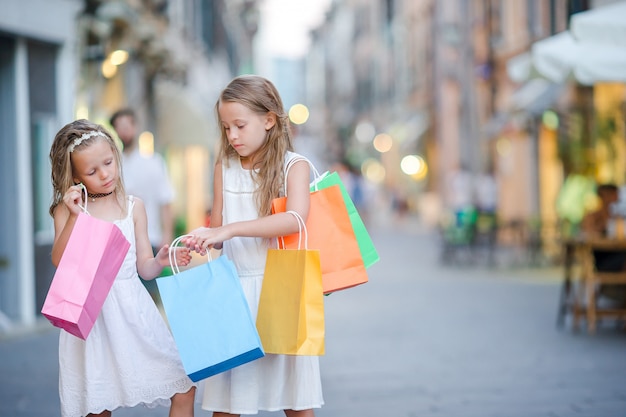 Muito sorridente meninas com sacolas de compras