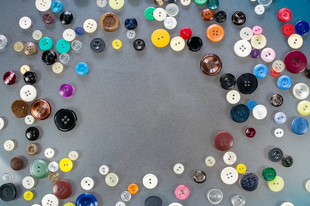 Muitos botões multicoloridos estão sobre a mesa, composição da moldura com copyspace