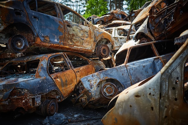 Foto muitos carros queimados enferrujados em irpen depois de serem baleados pelos militares russos guerra da rússia contra a ucrânia cemitério de carros destruídos de civis que tentaram evacuar da zona de guerra