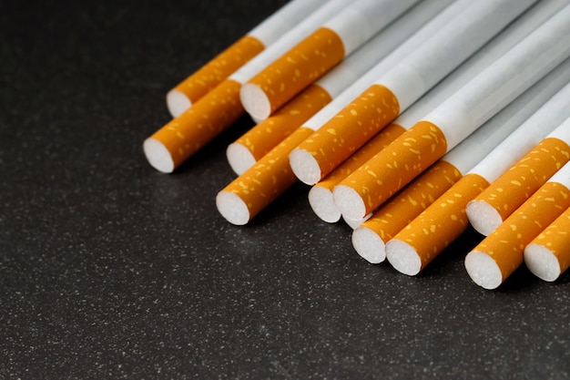 Muitos cigarros são colocados em um fundo preto, Eles são prejudiciais à saúde.