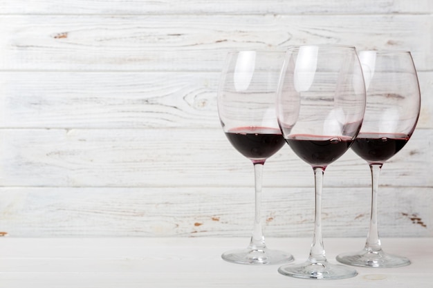 Muitos copos de vinho tinto na degustação de vinhos Conceito de vinho tinto em fundo colorido Vista superior design plano leigo