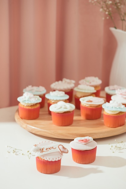 Muitos cupcakes saborosos. cupcake de amor doce dia dos namorados na mesa sobre fundo claro