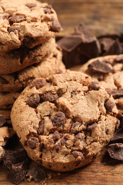 Muitos deliciosos biscoitos de chocolate na mesa de madeira closeup