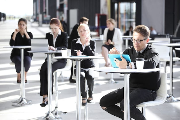 Muitos empresários sentados no café de um prédio de escritórios moderno