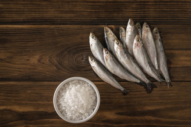 Muitos espadilhas e uma tigela de sal em uma mesa de madeira escura Delicioso aperitivo de frutos do mar