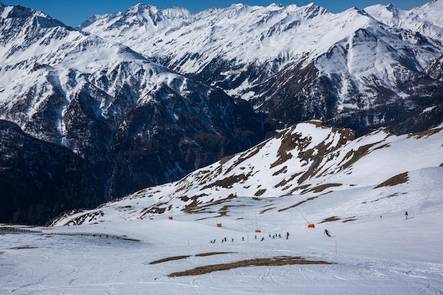Foto muitos esquiadores andam nos alpes no dia ensolarado de inverno paisagem de inverno panorama da estância de esqui com pistas de esqui alpes áustria