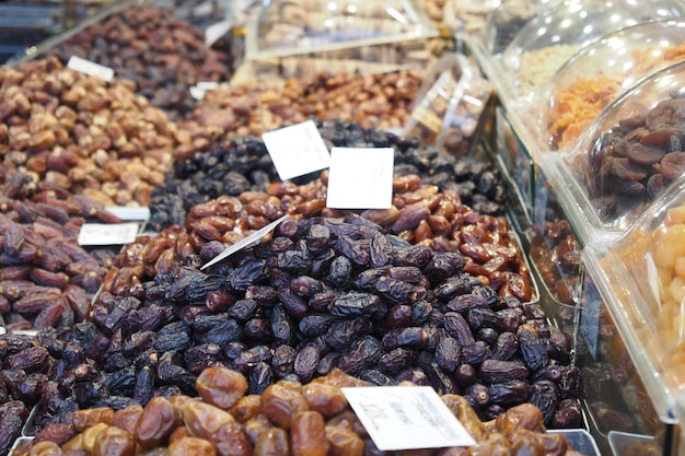 muitos expositores de frutas tâmaras à venda no mercado local