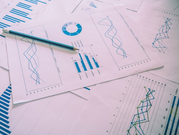 Muitos gráficos e gráficos com lápis-lápis. Luz de reflexão e flare. Imagem conceitual de coleta de dados e trabalho estatístico.