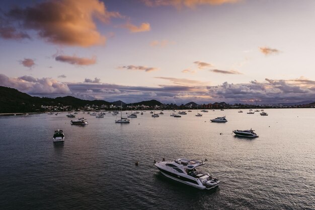 Muitos iates ancorados ao largo da costa ao pôr do sol Foto de alta qualidade