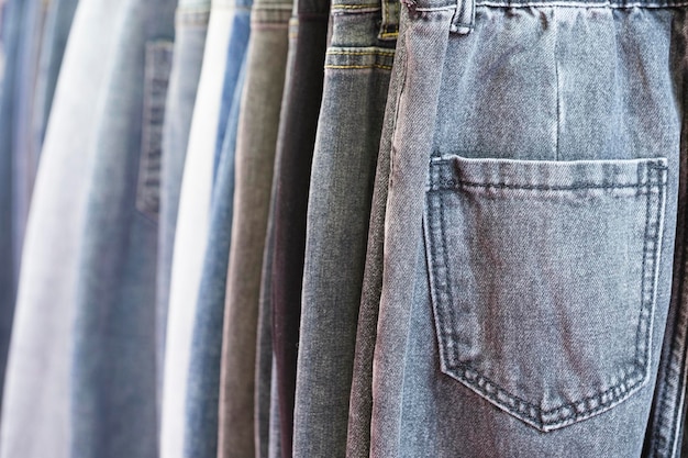 Muitos jeans pendurados em arack fila de calças jeans denim pendurado no armário conceito de comprar vender compras e jeans moda