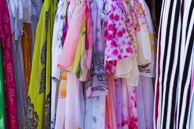 Muitos lenços femininos de primavera pendurados no mercado vietnamita