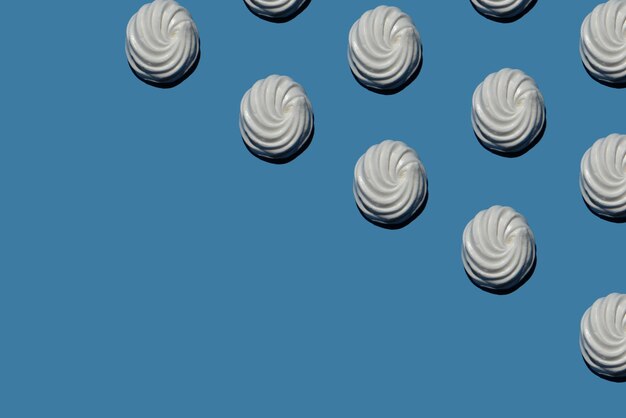 Muitos marshmallows doces em um padrão de fundo azul