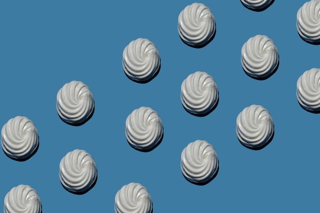 Muitos marshmallows doces em um padrão de fundo azul