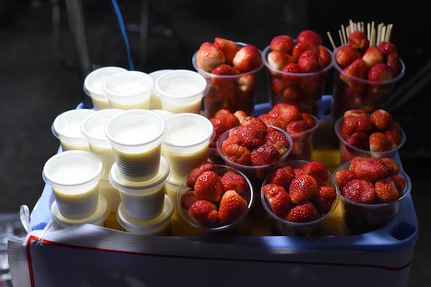 Muitos morangos e iogurte naturais frescos no mercado noturno vietnamita em Da Lat