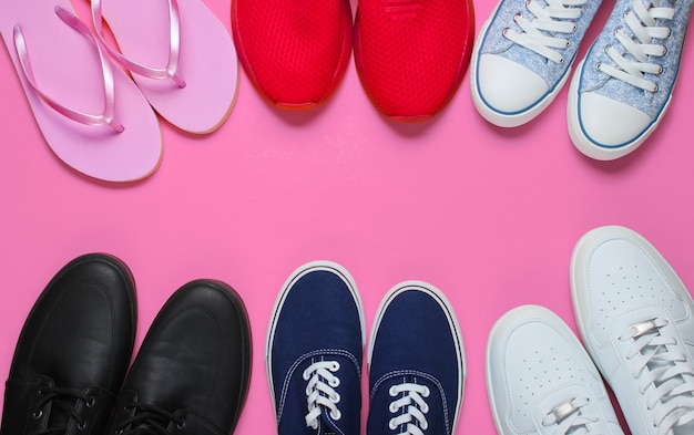 Muitos pares de sapatos em fundo rosa. conceito de moda minimalista. vista do topo. copie o espaço