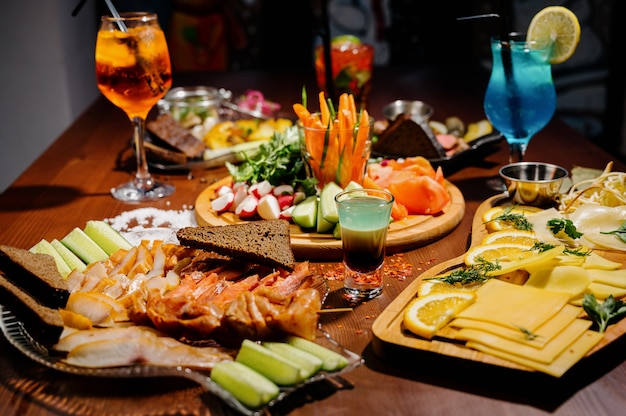 Foto muitos pratos deliciosos diferentes em cima da mesa. vários lanches e antepastos em cima da mesa. cardápio do restaurante.