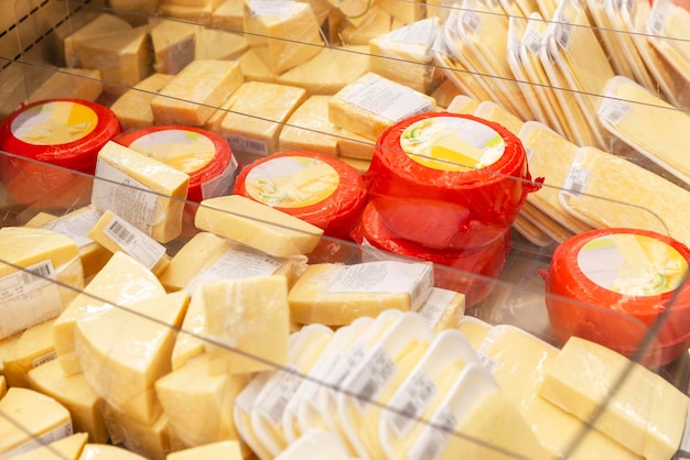 Muitos queijos diferentes na vitrine corte e cabeças inteiras