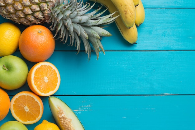 Muitos tipos de frutas deitado na mesa de madeira colorida.