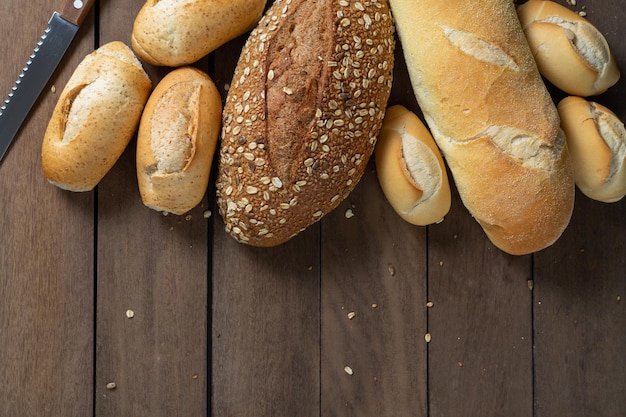 Muitos tipos de pão francês em uma mesa de madeira