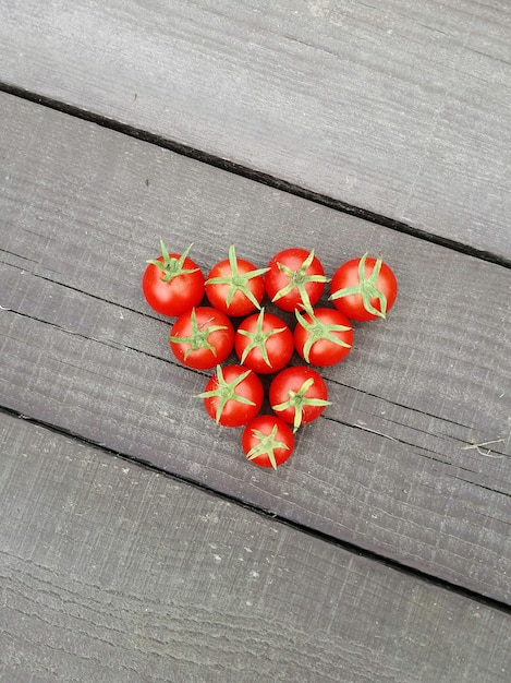 Muitos tomates cereja em uma superfície de madeira escura