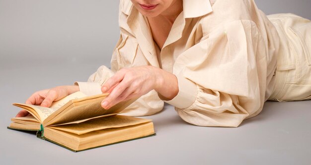 Mujer de 40 años con un libro sobre un fondo claro