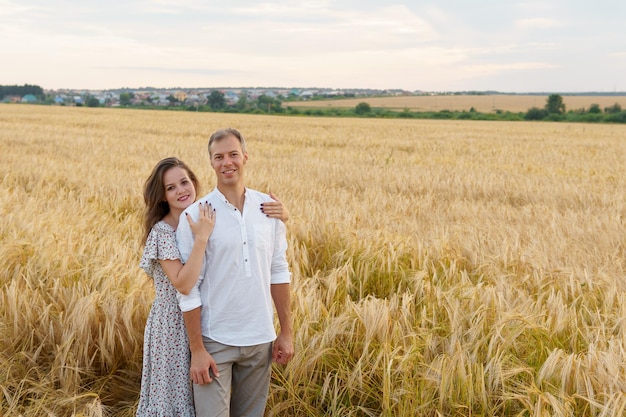 Mujer abraza a hombre caminando en un campo de trigo Amor pareja relación romántica