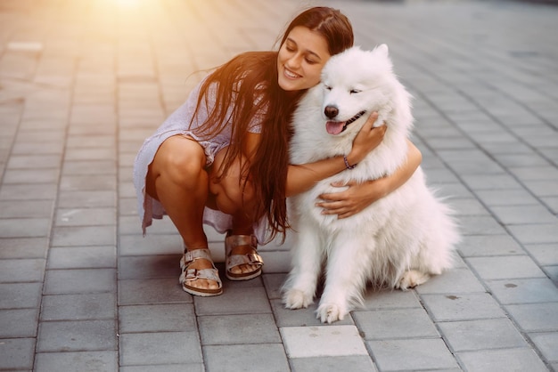 Mujer abraza a un perro grande al atardecer