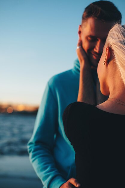 Foto mujer abrazando a un hombre contra el cielo azul