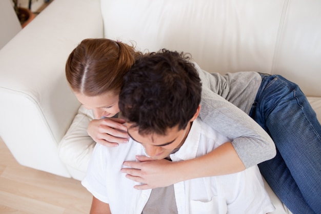 Mujer abrazando a su novio en el sofá