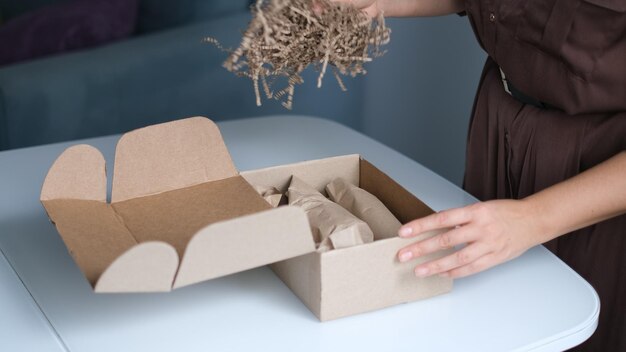 Foto mujer abriendo paquetes en el interior mujer abriando y desempaquetando paquetes en cajas de cartón