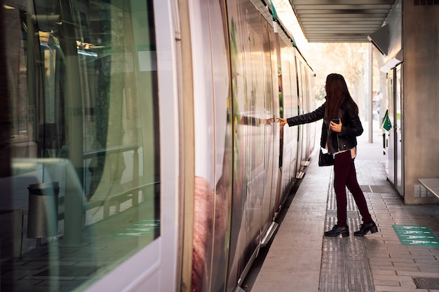 Mujer abriendo la puerta para abordar el tranvía