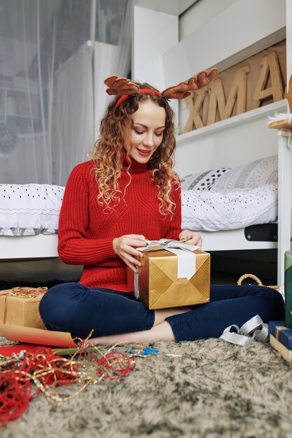 Mujer abriendo regalo de Navidad