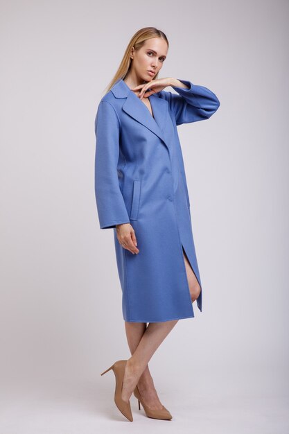Mujer en abrigo azul de otoño posando sobre fondo blanco Studio Shot Figura delgada
