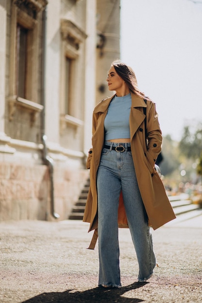 Mujer de abrigo beige caminando por la calle