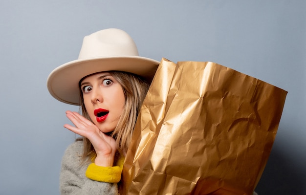 Mujer en abrigo con bolsa de compras