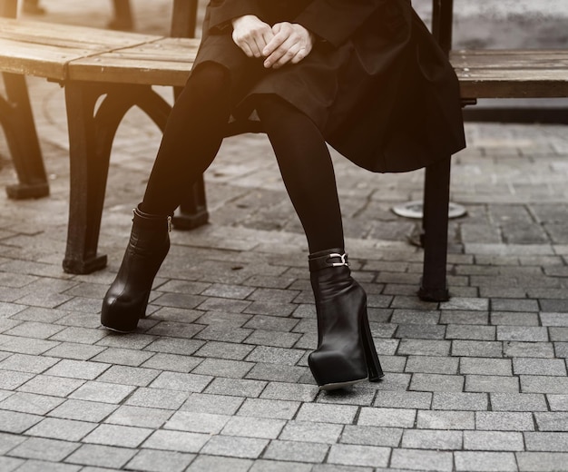 Mujer con abrigo negro y botas de cuero.