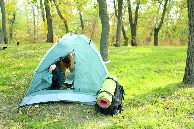 Una mujer abrió una tienda turística en la hierba verde en un bosque