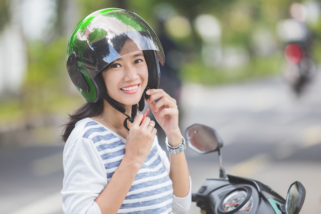 Mujer abrochando su casco de moto