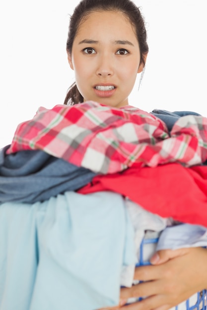 Mujer abrumada con la cantidad de ropa sucia