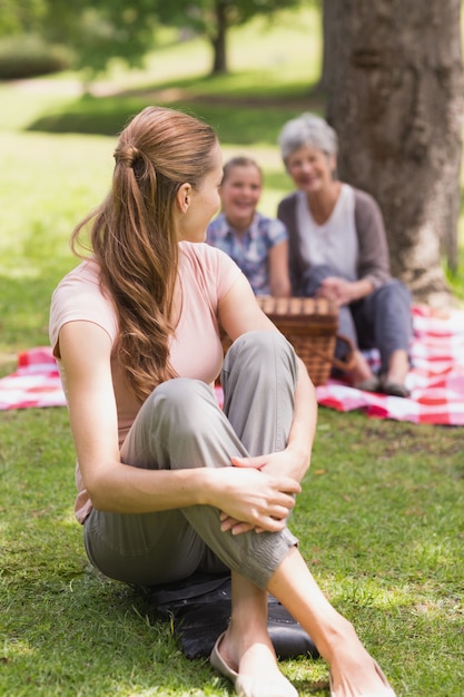 Mujer con abuela y nieta en el fondo en el parque