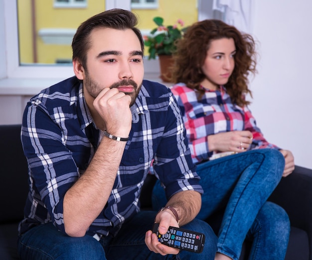 Mujer aburrida viendo tv con su novio