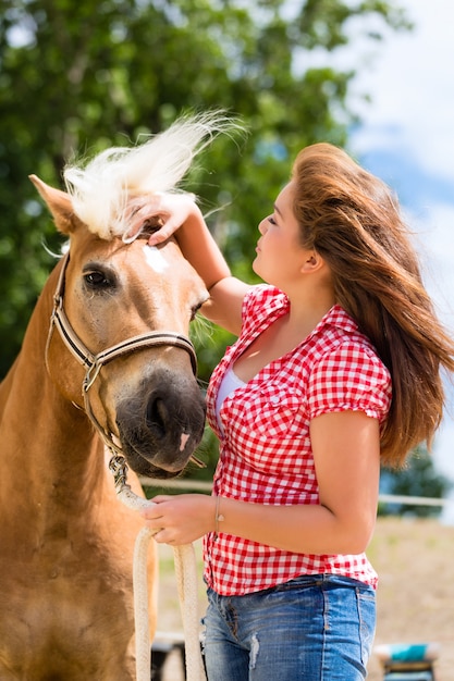Foto mujer acariciando a caballo en pony farm