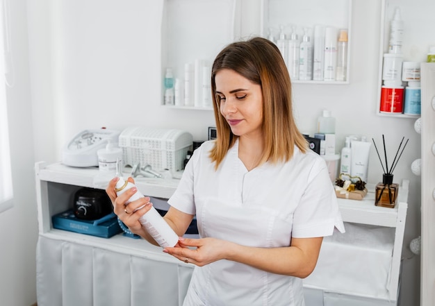 Mujer con aceite facial en la mano niña con un producto para el cuidado de la piel