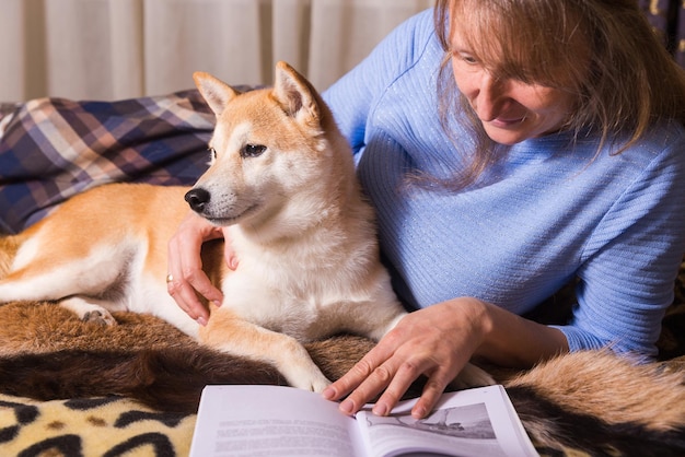 Una mujer acostada en la cama y leyendo un libro